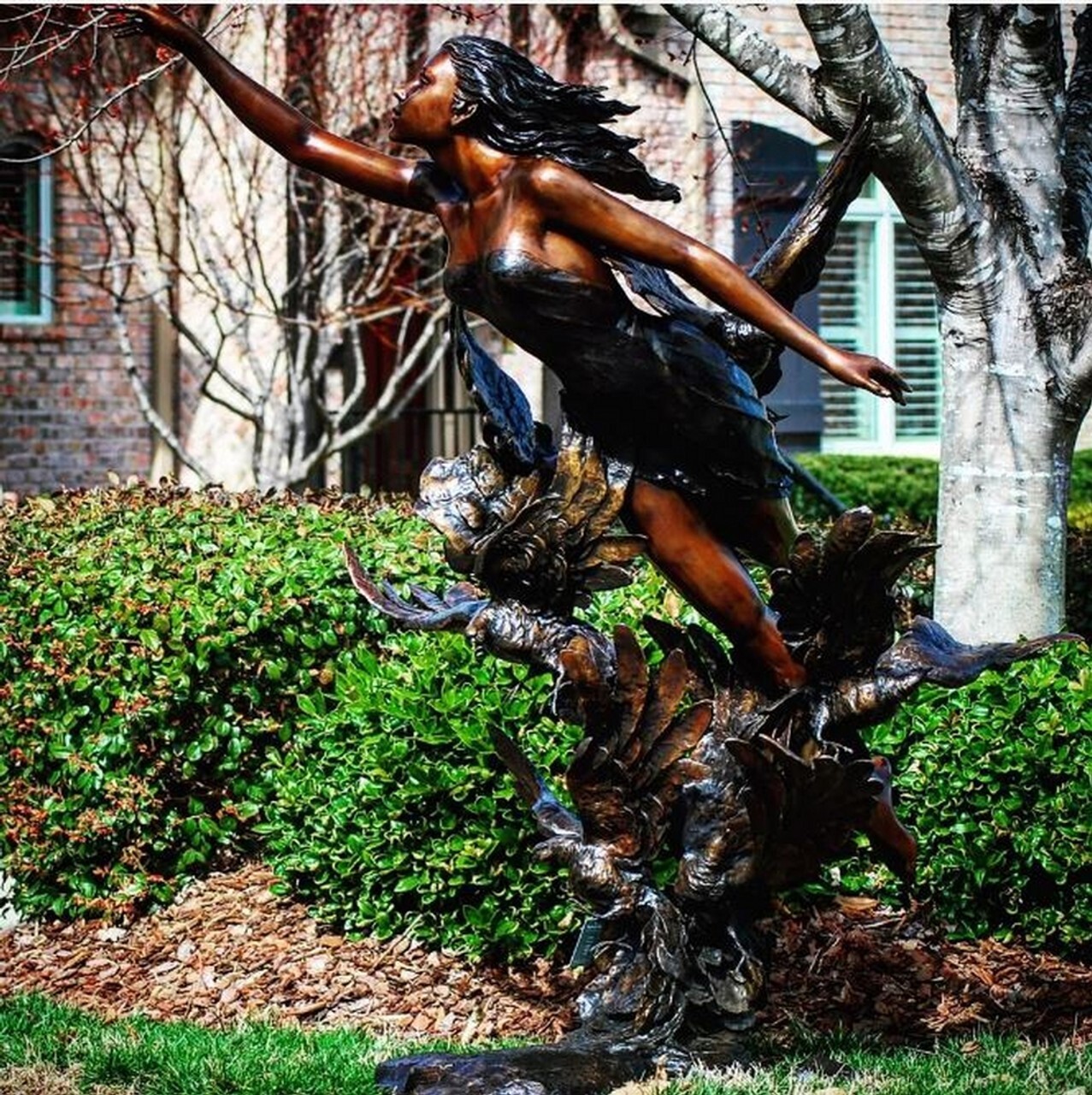 his spectacular bronze lady in clouds sculpture features a lady floating in the air with birds at her feet.