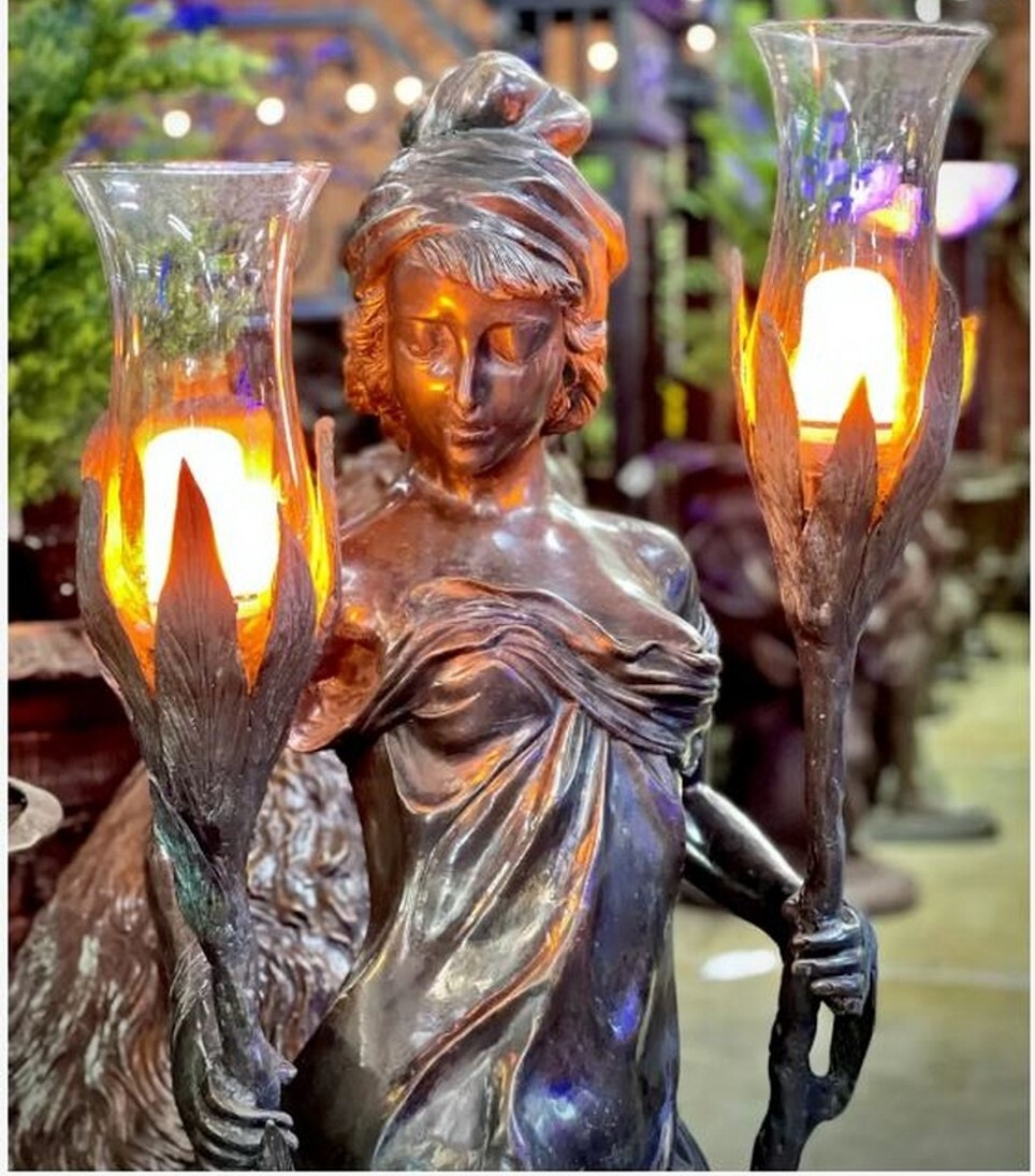 This magnificent bronze sculpture features a lady called Liana holding a pair of torchieres.
