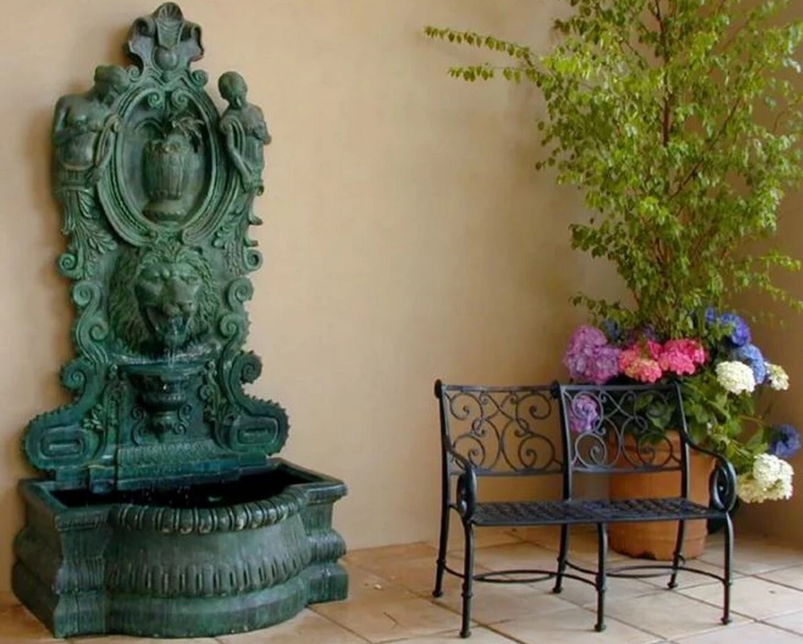 Transform your space with the Bronze Lion Head and Nymphs Wall Fountain Sculpture. 