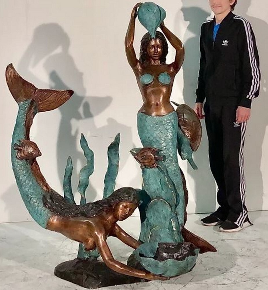 bronze fountain sculpture features a pair of mermaids in the ocean among reeds and sea life