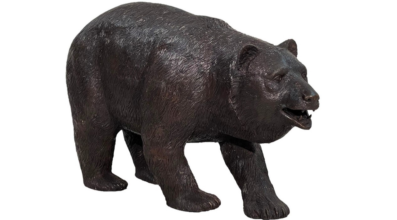 This bronze sculpture features a grizzly bear leisurely walking
