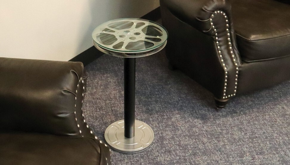 This unconventional 12 1/2 inch pedestal-style end table is made with a genuine Goldberg Brothers 16mm steel film reel.